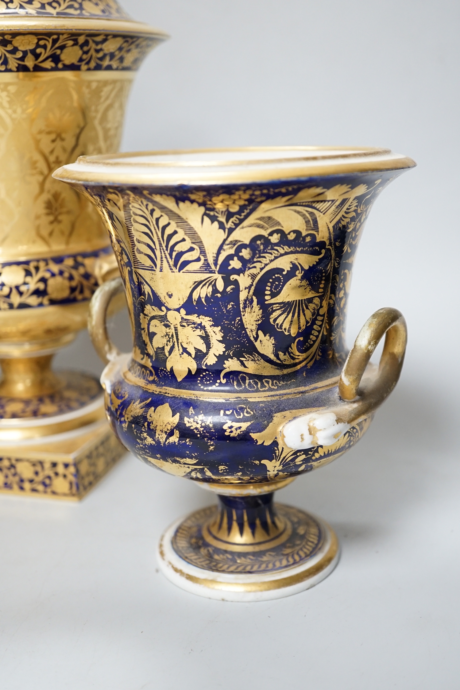 A pair of Derby flower basket painted urns, c.1810, and a larger Derby urn and cover, first quarter 19th century, latter 30cm